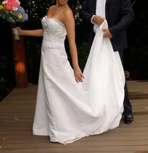 white A-line gown featuring a fitted, subtly ruched bodice with intricate beaded or embroidered detailing at the empire waist.