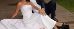 white A-line gown featuring a fitted, subtly ruched bodice with intricate beaded or embroidered detailing at the empire waist.